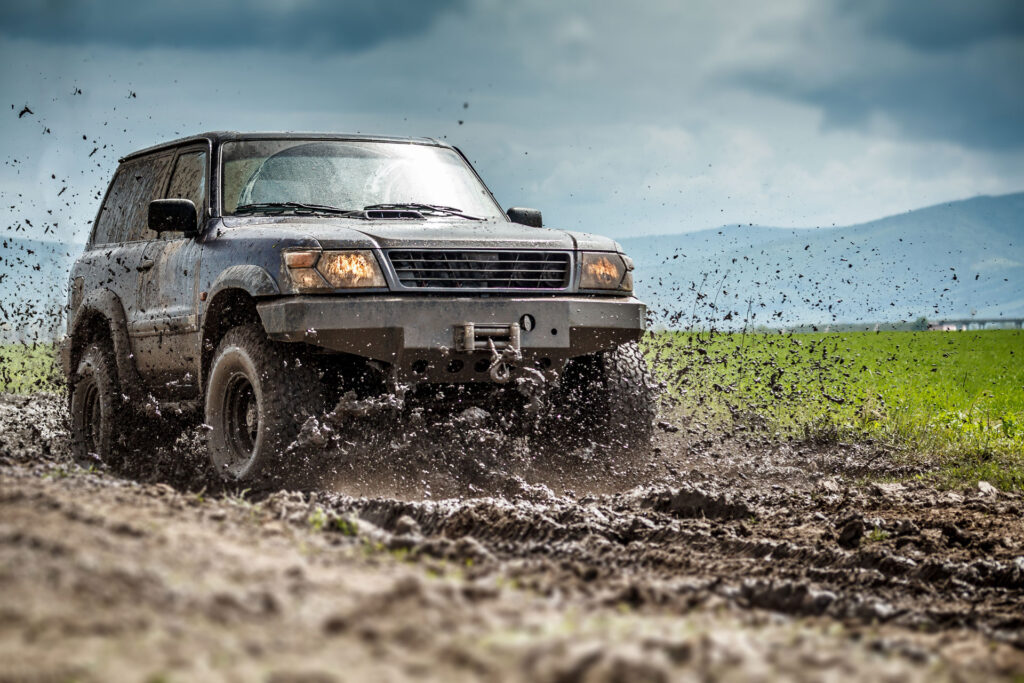 Off road car driving through mud